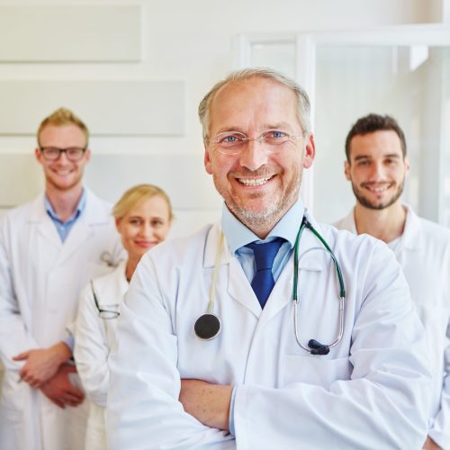 Successful doctor or physician with team at hospital